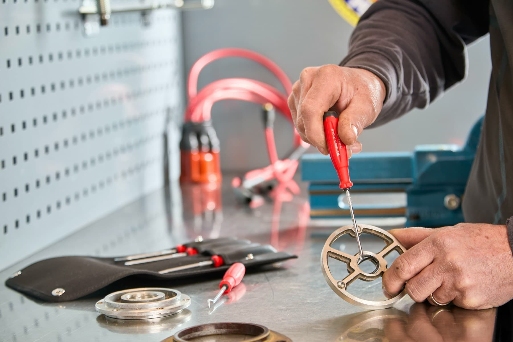 Hands assembling a precision mechanical component in a workshop